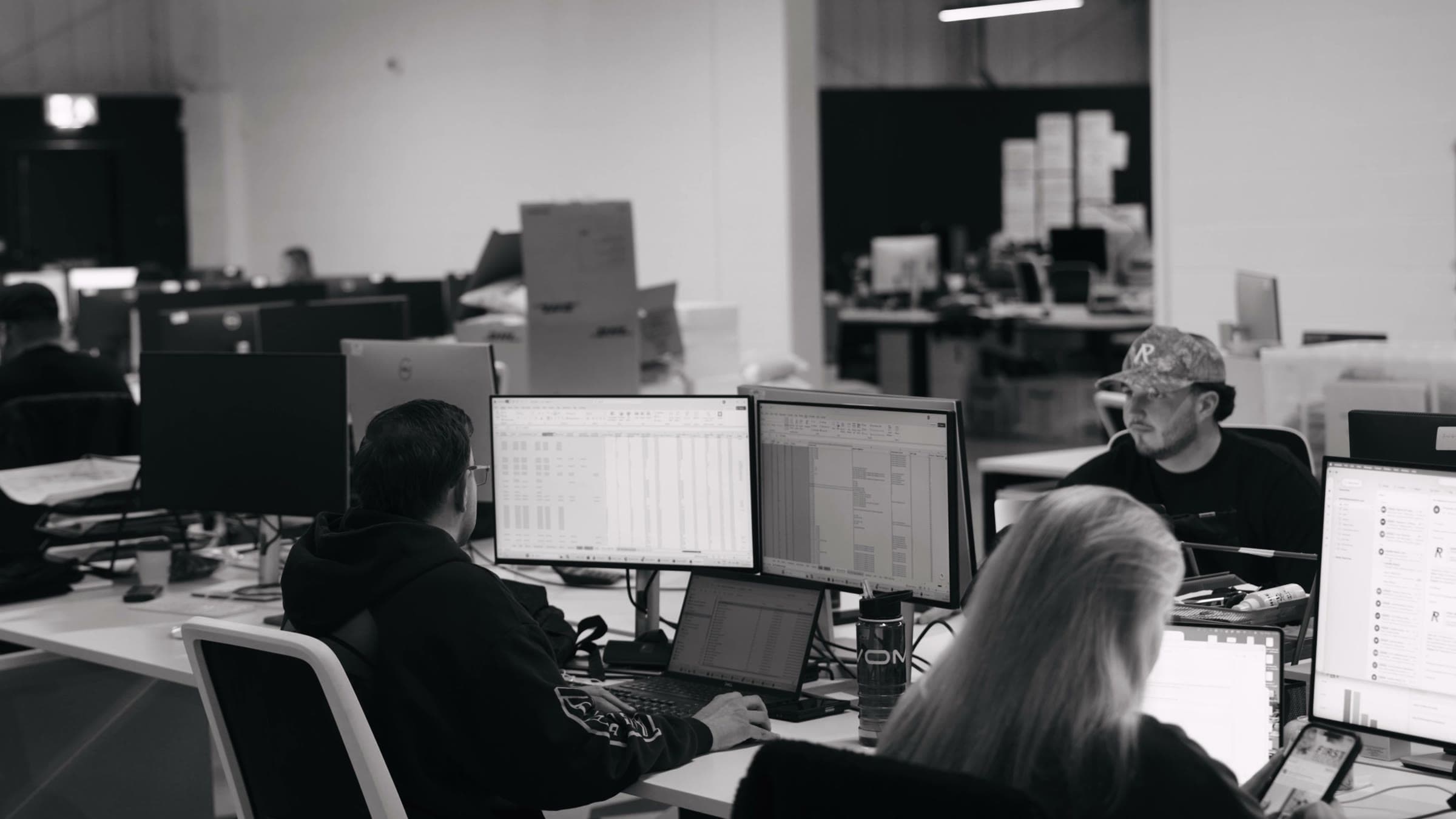 Represent's team at their desks, with spreadsheets open on their monitors